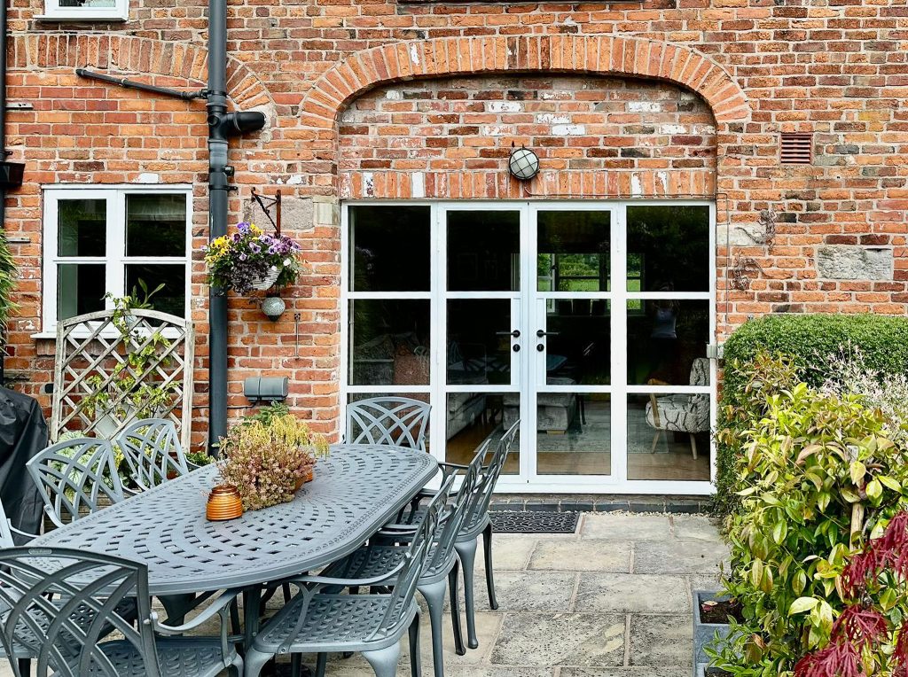 AD-55 heritage french doors in white finish with garden table in front
